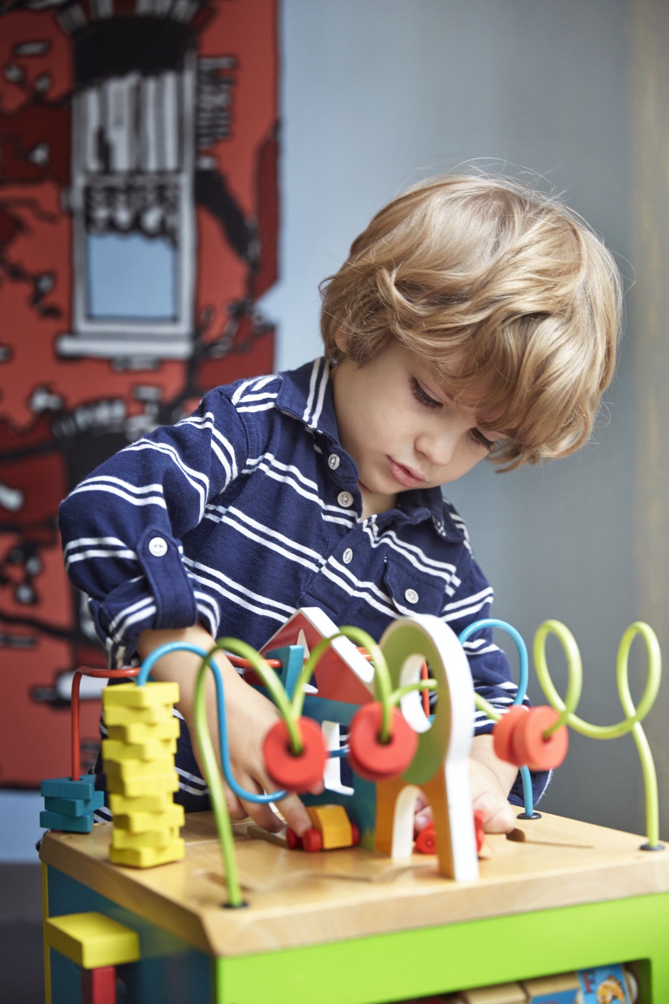 Boy Playing With Wooden Maze Toy At Kindergarten